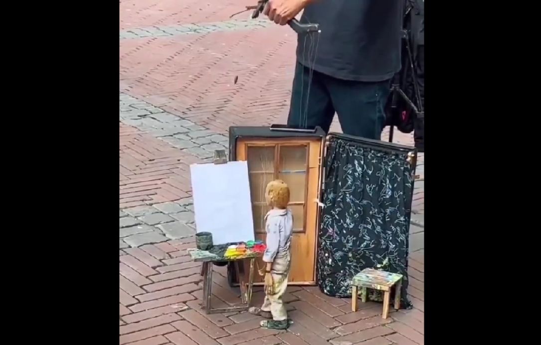 Pouliční umělec překvapuje lidi dovedností malovat pomocí loutky